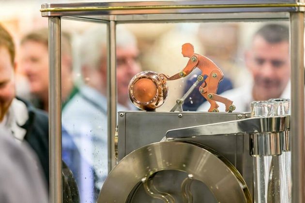 A mechanical man rolls a barrel inside the spirits safe on a still at the Vendome Copper and Brass Works booth on the vendor expo floor.