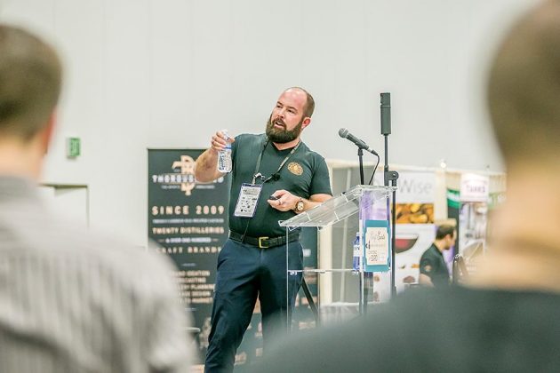 Distiller Chip Tate, of Tate Distillery, speaks to an overflow crowd on the expo stage about how the different aspects of a still affect flavor creation in distilled spirits.