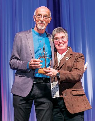 Master Distiller and Blender Hubert Germain-Robin, left, receives the lifetime achievement award for his contribution to the art of distilling from Nancy Fraley.